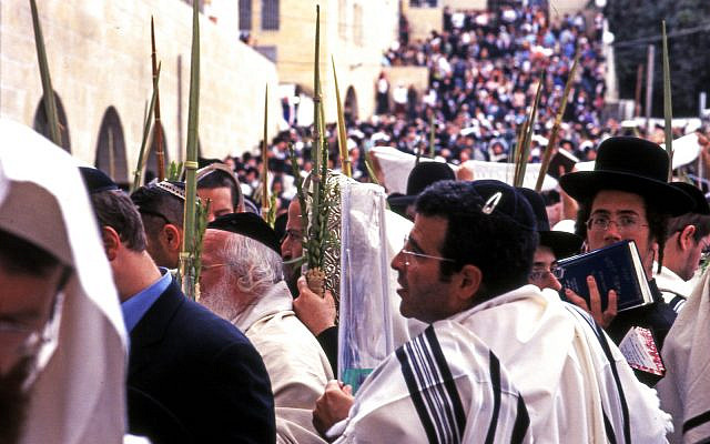 JERUSALEM, ISRAEL - October 14: Orthodox Jewish pray at the Western Wall during the Jewish holiday of Sukkot in Jerusalem, Israel. JERUSALEM, ISRAEL - October 14: Orthodox Jewish pray at the Western Wall during the Jewish holiday of Sukkot in Jerusalem, Israel.