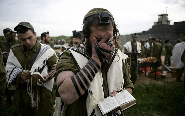 Illustrative: Religious soldiers of the Netzah Yehuda Battalion pray while completing the final stages of a 40 kilometer journey in 2010. (Abir Sultan/Flash90)
