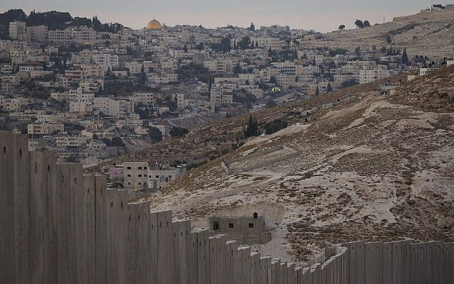 The Dome of the Rock in Jerusalem's Old City seen in the background of where the Palestinian side of the Separation Wall runs in the West Bank city of Abu-Dis. Israel says the barrier is necessary for security while Palestinians call it a land grab. September 29, 2014. Photo by Miriam Alster/FLASH90