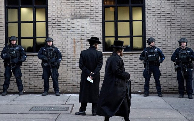New York City police guard a Brooklyn synagogue, prior to a funeral for Moshe Deutsch, December 11, 2019, a rabbinical student from Brooklyn, who was killed in the shooting inside a Jersey City, NJ kosher market. (AP Photo/Mark Lennihan)