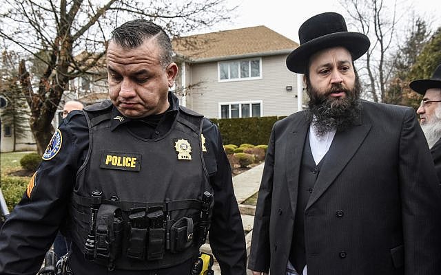 A member of the Ramapo police stands guard in front of the house of Rabbi Chaim Rottenberg, Dec. 29, 2019, in Monsey, New York. Five people were injured in a knife attack during a Hanukkah party. (Stephanie Keith/Getty Images)