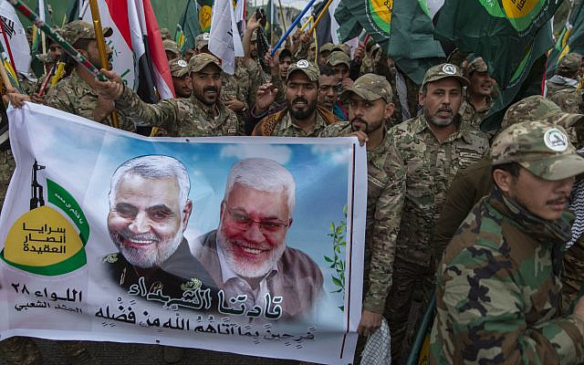 Iraqi militiamen march and chant anti U.S. slogans while carrying a picture of Soleimani, left and al-Muhandis, with Arabic that reads "our Martyr leaders," during the funeral of Iran's top general Qassem Soleimani and Abu Mahdi al-Muhandis, deputy commander of Iran-backed militias in Iraq known as the Popular Mobilization Forces, in Baghdad, Iraq, Saturday, Jan. 4, 2020. . (AP Photo/Nasser Nasser via Jewish News) Iraqi militiamen march and chant anti U.S. slogans while carrying a picture of Soleimani, left and al-Muhandis, with Arabic that reads "our Martyr leaders," during the funeral of Iran's top general Qassem Soleimani and Abu Mahdi al-Muhandis, deputy commander of Iran-backed militias in Iraq known as the Popular Mobilization Forces, in Baghdad, Iraq, Saturday, Jan. 4, 2020. . (AP Photo/Nasser Nasser via Jewish News)