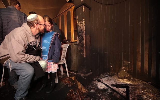 A father and daughter examine the damage to the mosque burned in a "Price Tag" attack. Photo credit: Yossi Zamir, Tag Meir.