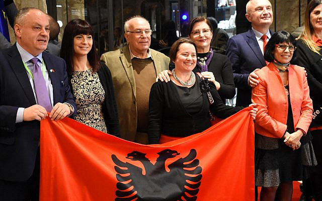 Bardhyl Canaj, Albania's ambassador to Israel, at far left, holds up one corner of the Albanian flag. Joining him are members of Israel's tiny Albanian Jewish community and Albanian President Ilir Meta, at far right. (Larry Luxner) Bardhyl Canaj, Albania's ambassador to Israel, at far left, holds up one corner of the Albanian flag. Joining him are members of Israel's tiny Albanian Jewish community and Albanian President Ilir Meta, at far right. (Larry Luxner)