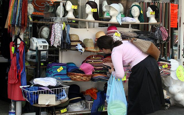 Illustrative. A young woman chooses from a selection of headcoverings worn by ultra-Orthodox Jewish women, once they are married. June 6, 2008. (Lara Savage/ Flash 90/File)