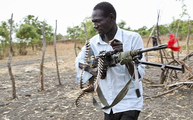 ILLUSTRATIVE: An opposition fighter In South Sudan walks with his weapon. Sunday, Jan. 21, 2018. (AP/Sam Mednick)
