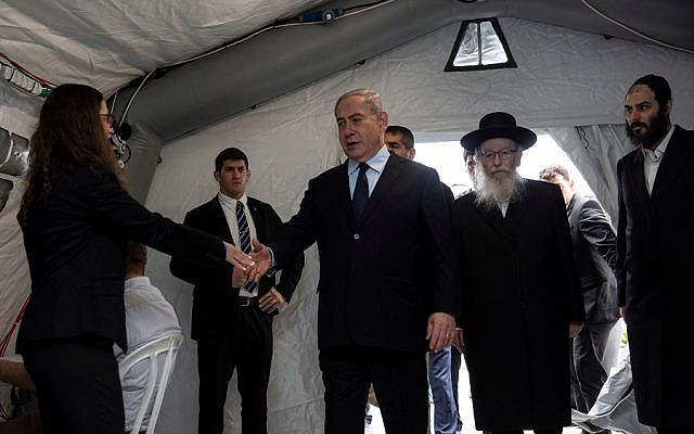 Israeli Prime Minister Benjamin Netanyahu arrives to a tent during his visit to the Chaim Sheba Medical Center at Tel Hashomer in Ramat Gan, Israel, for discussion on the coronavirus, February 19, 2020. Heidi Levine/Poolvia REUTERS