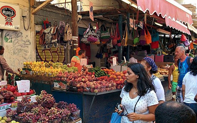 The Shuk HaCarmel in Tel Aviv, pictured here in busier times, has been shuttered due to the coronavirus pandemic. Other shopping outlets have taken advantage of the time to hike up product prices. (Wikimedia Commons)