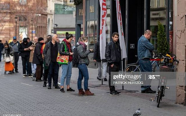 Customers wait in front of a supermarket in central Strasbourg, eastern France, on March 17, 2020, a few hours before the order of staying at home to all French citizens comes into effect, in order to avoid the spreading of the novel coronavirus. - In a live television address on March 16, 2020, French President Emmanuel Macron ordered people to stay at home to avoid spreading the new coronavirus, saying only necessary trips would be allowed and violations would be punished. France had already announced stringent new measures to close bars, restaurants and cinemas, which came after the closure of schools and a ban on large gatherings. (Photo by PATRICK HERTZOG / AFP) (Photo by PATRICK HERTZOG/AFP via Getty Images)