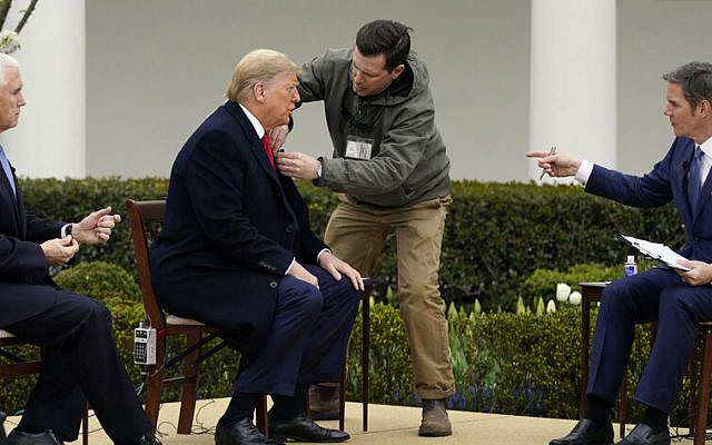 President Donald Trump arrives and speaks with Fox News Channel Anchor Bill Hemmer, as Vice President Mike Pence looks on, during a Fox News Channel virtual town hall, at the White House, Tuesday, March 24, 2020, in Washington. (AP Photo/Evan Vucci)