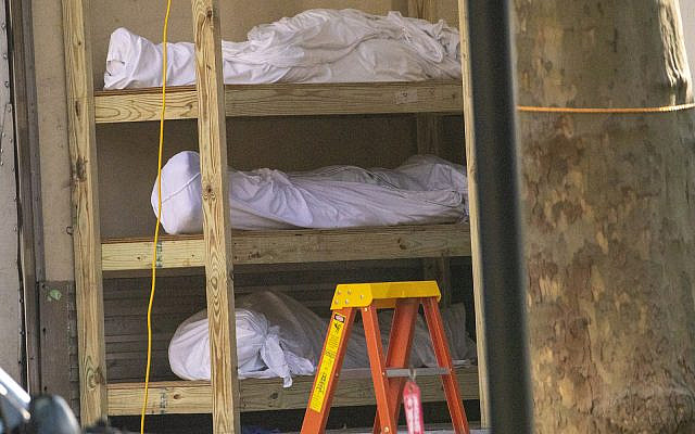Bodies are seen on shelves in a refrigerated container at Kingsbrook Jewish Medical Center, Wednesday, April 8, 2020, in New York. (AP Photo/Mary Altaffer)