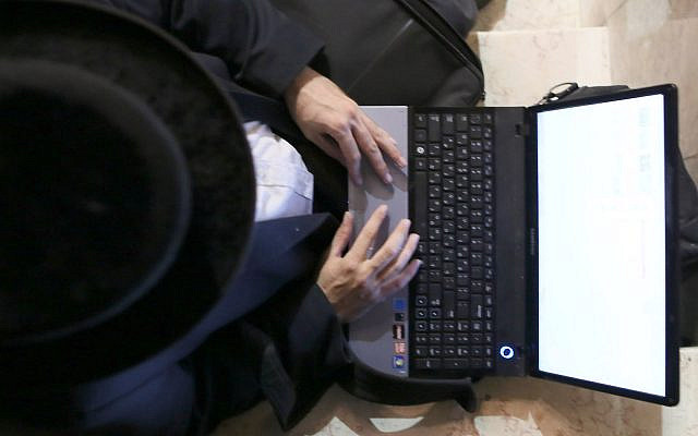 Illustrative: Ultra orthodox jewish photographer Moshe Friedman edits his pictures on a laptop, after photographing a wedding in the ultra orthodox neighborhood of Meah Shearim, in Jerusalem. August 28, 2012. (Nati Shohat/FLASH90)