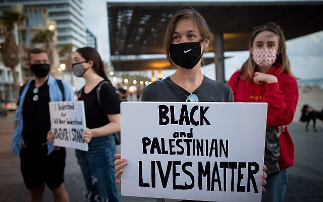 Israelis holds signs during a protest against the death in Minneapolis police custody of George Floyd outside the US consulate in Tel Aviv on June 02 2020 (Miriam Alster/Flash90) Israelis holds signs during a protest against the death in Minneapolis police custody of George Floyd outside the US consulate in Tel Aviv on June 02 2020 (Miriam Alster/Flash90)