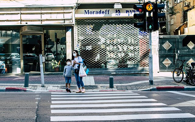 Tel Aviv Israel April 02, 2020 View of unidentified people with a mask walking in the empty streets of Tel Aviv during the quarantine of the population to prevent the spread of the coronavirus. (Depositphotos)