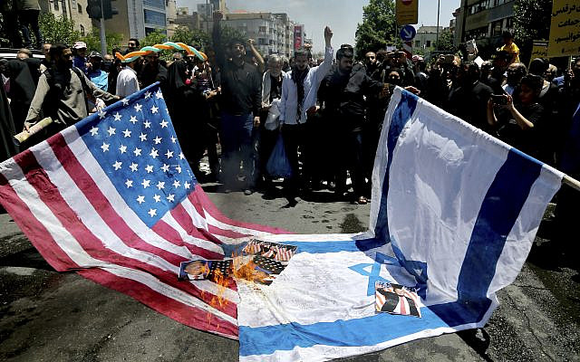 Iranian protesters burn Israeli and US flags in their annual anti-Israeli Al-Quds, Jerusalem, Day rally in Tehran, Iran, June 8, 2018. Iranians attended the rallies across the country to condemn Israeli occupation of Palestinian territories. (AP Photo/ Ebrahim Noroozi)