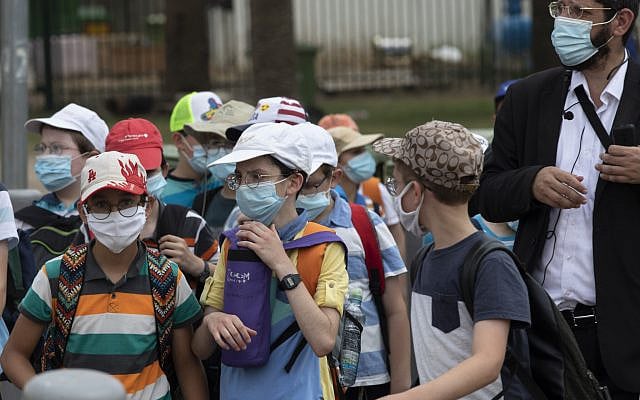 Israeli school children wear face masks to help prevent the spread of the coronavirus as they walk in Tel Aviv, July 6, 2020. (AP Photo/Sebastian Scheiner)