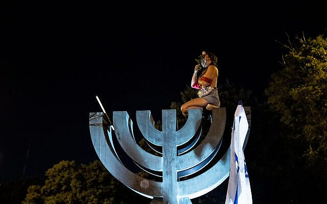 A bare breasted woman atop the menorah outside the Israeli parliament in Jerusalem on July 21, 2020. Photo by Yonatan Sindel/Flash90 A bare breasted woman atop the menorah outside the Israeli parliament in Jerusalem on July 21, 2020. Photo by Yonatan Sindel/Flash90