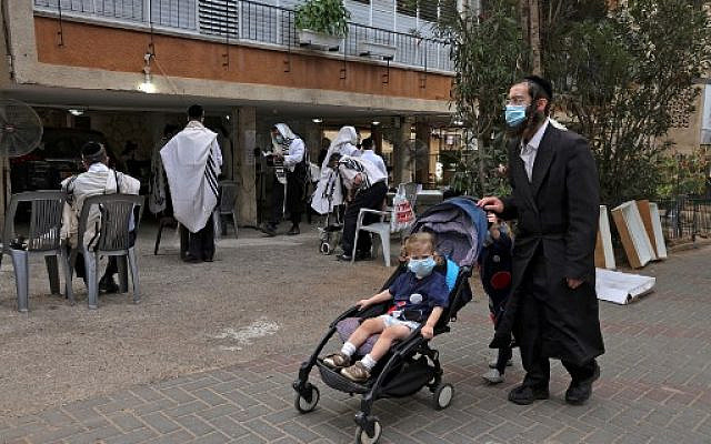 Men praying outside a synagogue to prevent or diminish outbreaks of COVID-19, in the ultra-Orthodox city of Bnei Brak, September 6, 2020. (MENAHEM KAHANA/ AFP)