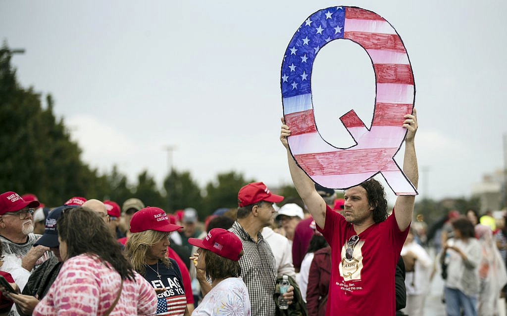 David Reinert, a QAnon founder, holding a Q sign waits in line with others to enter a campaign rally with President Donald Trump and Republican US Senate candidate Rep. Lou Barletta, R-Pa., August 2, 2018, in Wilkes-Barre, Pennsylvania (AP Photo/ Matt Rourke)