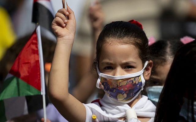 A Palestinian girl wearing a protective face mask amid the coronavirus pandemic takes part in a rally in support of Palestinian President Mahmoud Abbas in the West Bank town of Tubas, Sunday, Sept. 27, 2020. (AP Photo/Majdi Mohammed) A Palestinian girl wearing a protective face mask amid the coronavirus pandemic takes part in a rally in support of Palestinian President Mahmoud Abbas in the West Bank town of Tubas, Sunday, Sept. 27, 2020. (AP Photo/Majdi Mohammed)