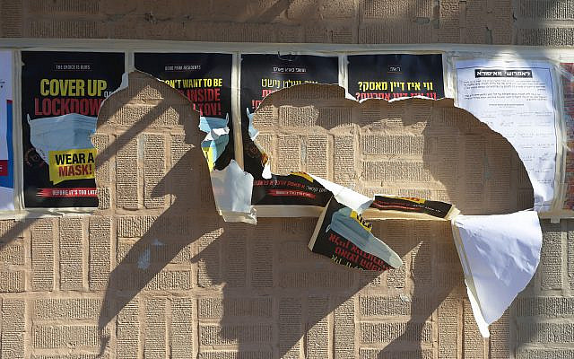 Torn signs that had warned against the dangers of the coronavirus pandemic, posted on a wall in the Borough Park neighborhood of Brooklyn, on October 7, 2020. (Michael M. Santiago/Getty Images)