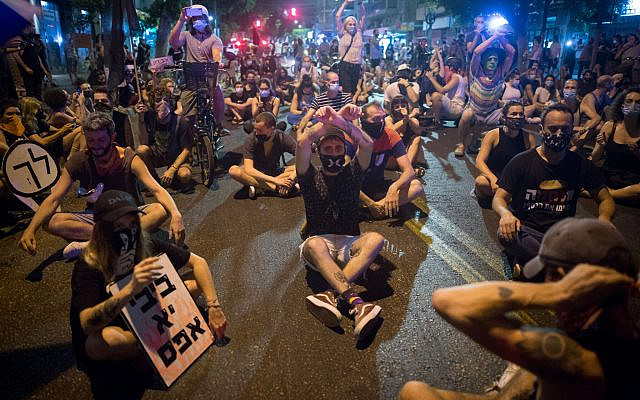 Protesters block a road as they protest against Prime Minister Benjamin Netanyahu in Tel Aviv, on September 30, 2020. (Miriam Alster/Flash90) Protesters block a road as they protest against Prime Minister Benjamin Netanyahu in Tel Aviv, on September 30, 2020. (Miriam Alster/Flash90)