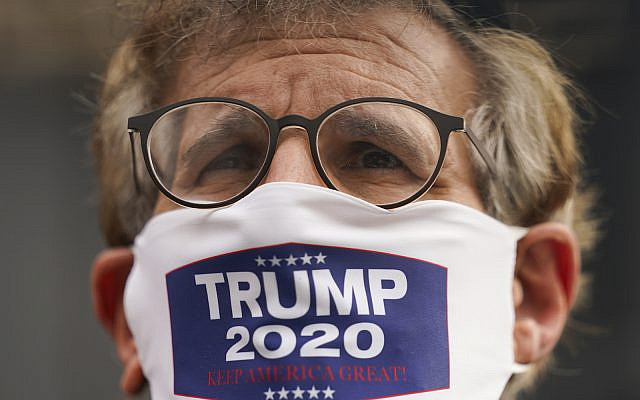 A member of the Jewish Orthodox community wears a mask supporting President Donald Trump, Wednesday, Oct. 7, 2020, in Borough Park, Brooklyn, New York. (AP Photo/John Minchillo)