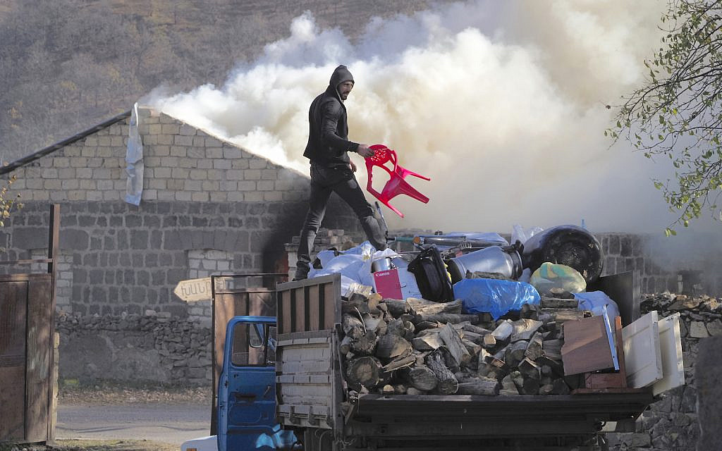 A man loads possessions on his truck after setting his home on fire, in an area once occupied by Armenian forces but soon to be turned over to Azerbaijan, in Karvachar, the separatist region of Nagorno-Karabakh, on Friday, Nov. 13, 2020. Under an agreement ending weeks of intense fighting over the Nagorno-Karabakh region, some Armenian-held territories adjacent to the region are passing to Azerbaijan. (AP Photo/Dmitry Lovetsky) A man loads possessions on his truck after setting his home on fire, in an area once occupied by Armenian forces but soon to be turned over to Azerbaijan, in Karvachar, the separatist region of Nagorno-Karabakh, on Friday, Nov. 13, 2020. Under an agreement ending weeks of intense fighting over the Nagorno-Karabakh region, some Armenian-held territories adjacent to the region are passing to Azerbaijan. (AP Photo/Dmitry Lovetsky)