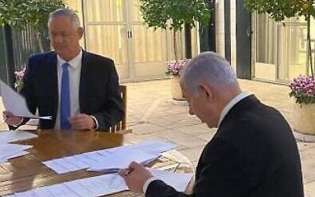 Blue and White leader Benny Gantz (left) and Prime Minister Benjamin Netanyahu sign their unity government agreement on April 20, 2020. (courtesy) Blue and White leader Benny Gantz (left) and Prime Minister Benjamin Netanyahu sign their unity government agreement on April 20, 2020. (courtesy)
