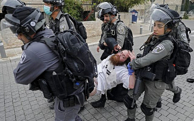 Israeli security forces arrest an Ultra-Orthodox Jewish man as they close a synagogue in the Mea Shearim Ultra-Orthodox neighbourhood in Jerusalem, on March 30, 2020, amid efforts to curb the spread of the COVID-19 coronavirus pandemic. (Photo by Ahmad GHARABLI / AFP) Israeli security forces arrest an Ultra-Orthodox Jewish man as they close a synagogue in the Mea Shearim Ultra-Orthodox neighbourhood in Jerusalem, on March 30, 2020, amid efforts to curb the spread of the COVID-19 coronavirus pandemic. (Photo by Ahmad GHARABLI / AFP)