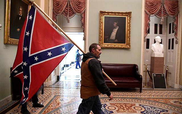 A supporter of President Donald Trump carries a Confederate battle flag on the second floor of the U.S. Capitol near the entrance to the Senate after breaching security defenses, in Washington, U.S., January 6, 2021.         REUTERS/Mike Theiler     TPX IMAGES OF THE DAY
