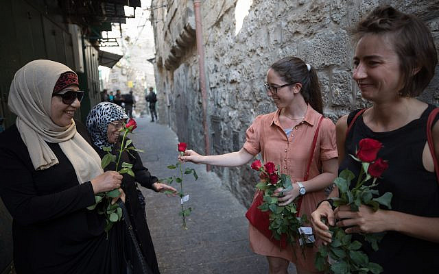 Illustrative: Israelis pass out roses to Arabs in the Muslim quarter of Jerusalem's old City, during Jerusalem Day. May 24, 2017.  (Nati Shohat/Flash90)