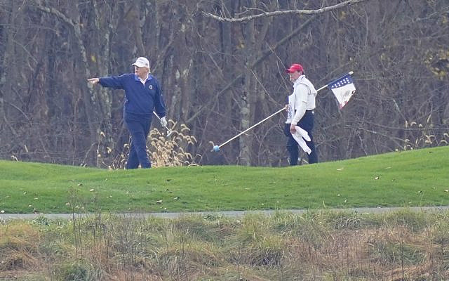 US President Donald Trump, left, gesturing while playing golf at Trump National Golf Club in Sterling, Virginia, November 15, 2020. (Manuel Balce Ceneta/AP) US President Donald Trump, left, gesturing while playing golf at Trump National Golf Club in Sterling, Virginia, November 15, 2020. (Manuel Balce Ceneta/AP)