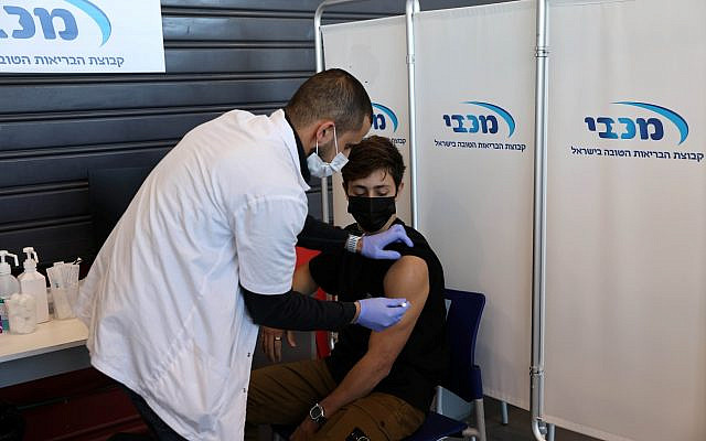 A teenager receives a vaccination against the coronavirus disease (COVID-19), in Tel Aviv, Israel, January 24, 2021. REUTERS/Ronen Zvulun