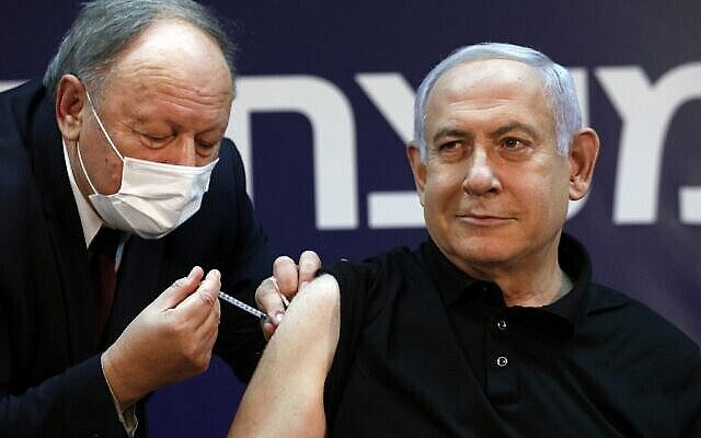 Israeli Prime Minister Benjamin Netanyahu receives a coronavirus vaccine at the Sheba Medical Center, the country's largest hospital, in Ramat Gan near the coastal city of Tel Aviv, on December 19, 2020. - Netanyahu, 71, and Israel's health minister were injected with the Pfizer-BioNTech vaccine live on TV at Sheba Medical Center. Each recipient must receive a booster shot in three weeks for optimal protection from the novel coronavirus. (Photo by AMIR COHEN / POOL / AFP)
