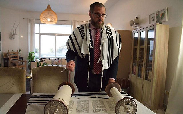 Alex Peterfreund, a co-founder of Dubai’s Jewish community, its cantor, and an AGJC board member with a Torah scroll in Dubai, United Arab Emirates, August 16, 2020. (AP Photo/Jon Gambrell)