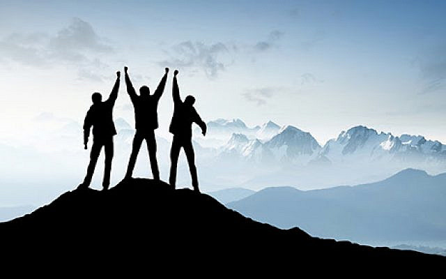 Silhouettes of a team on mountain peak. Sport and active life concept