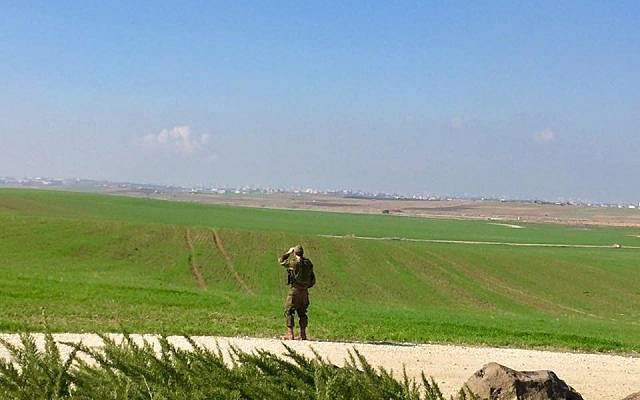 An Israeli soldier looks across the border at Gaza in the distance. (Photo credit:Andrew Getraer)