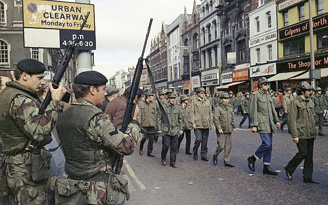 In this Aug. 1972 file photo British troops watch as members of the Ulster Defence Association parade through Belfast, Northern Ireland during the violent 30-year Catholic-Protestant conflict known as "The Troubles." (AP Photo, File)