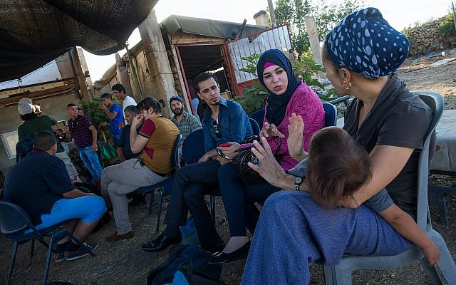 Israeli Jews and Palestinians talk to each other, during a weekly meeting organized by Ali Abu Awwad, a Palestinian from the West Bank, on July 22, 2015. Ali organizes meetings between Jews and Palestinians at his home, to promote cooperation and co-existence. (Nati Shohat/Flash90/File)