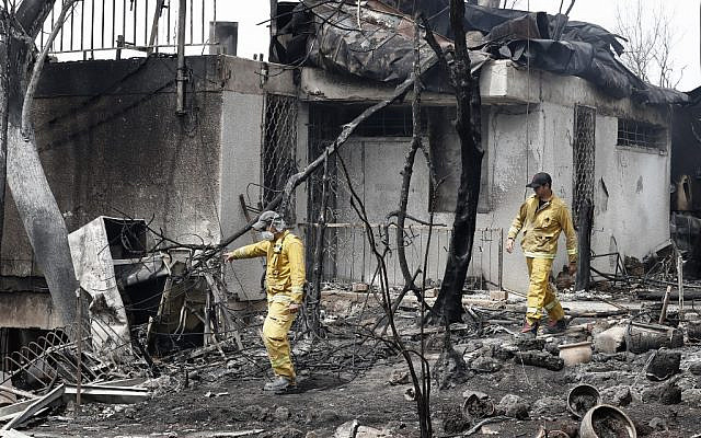 Israeli firefighters check a house that was badly damaged by a fire amid an extreme heat wave in the village of Mevo Modi'im, in central Israel on May 24, 2019. (JACK GUEZ / AFP) Israeli firefighters check a house that was badly damaged by a fire amid an extreme heat wave in the village of Mevo Modi'im, in central Israel on May 24, 2019. (JACK GUEZ / AFP)