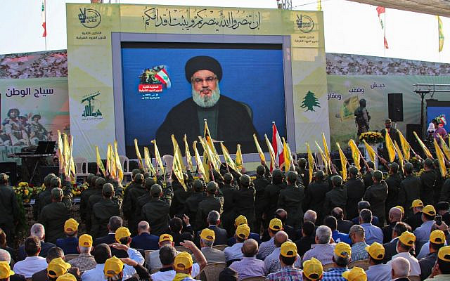 Supporters of the Shiite Hezbollah terror group gather to watch the transmission on a large screen of a speech by the movement's leader Hassan Nasrallah, in the town of Al-Ain in Lebanon's Bekaa valley on August 25, 2019. (AFP)