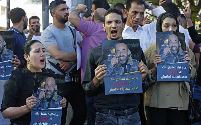 Palestinians hold posters depicting human rights activist Nizar Banat during a protest triggered by the violent arrest and death in custody of Banat, in his hometown of Hebron in the occupied West Bank, on June 27, 2021. (MOSAB SHAWER / AFP) Palestinians hold posters depicting human rights activist Nizar Banat during a protest triggered by the violent arrest and death in custody of Banat, in his hometown of Hebron in the occupied West Bank, on June 27, 2021. (MOSAB SHAWER / AFP)