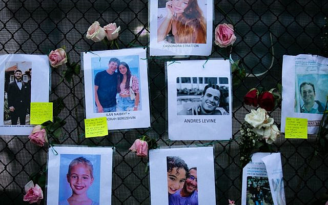 Images of Andres Levine, Ilan Naibryf and Deborah Berezdivin, three of the Jewish victims of the Surfside building collapse, in center among other photographs of those missing posted at a makeshift memorial on the building site in Surfside, Fla., June 26, 2021. (Andrea Sarcos/AFP) Images of Andres Levine, Ilan Naibryf and Deborah Berezdivin, three of the Jewish victims of the Surfside building collapse, in center among other photographs of those missing posted at a makeshift memorial on the building site in Surfside, Fla., June 26, 2021. (Andrea Sarcos/AFP)