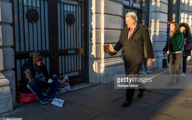 Passers-by ignore a homeless man begging with a sign saying 'I'm hungry', on the pavement in Piccadilly, on 20th January 2020, in London, England. (Photo by Richard Baker / In Pictures via Getty Images)