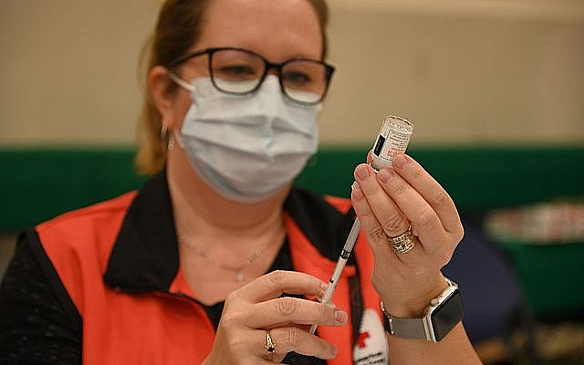 210109-N-OX321-2038 NAVAL AIR STATION SIGONELLA, ITALY (Jan. 9, 2021)-- Angeline Mitchell, registered nurse and American Red Cross volunteer, prepares shots of the Moderna COVID-19 vaccine for the inoculations of critical medical staff and first responder volunteers onboard Naval Air Station (NAS) Sigonella, Jan. 9, 2021. NAS Sigonella’s strategic location enables U.S., allied, and partner nation forces to deploy and respond as required to ensure security and stability in Europe, Africa and Central Command. (U.S. Navy photo by Mass Communication Specialist 1st Class Kegan E. Kay)..
