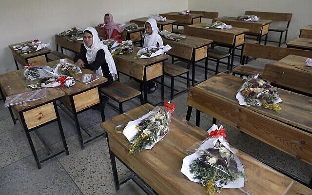 FILE-in this May 16, 2021 file photo, Schoolgirls sit inside a classroom with bouquets of flowers on empty desks as a tribute to those killed in the brutal May 8 bombing of the Syed Al-Shahda girls school, in Kabul, Afghanistan. In a report released Monday, July 26, 2021, the United Nations said that more women and children were killed and wounded in Afghanistan in the first half of 2021 than in any year since the UN began keeping count in 2009 (AP Photo/Rahmat Gul, File)