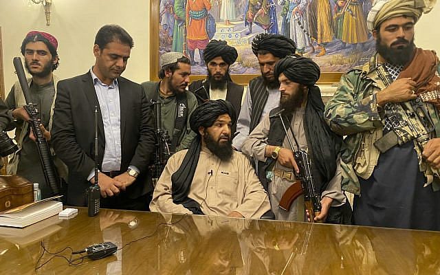 Taliban fighters take control of the Afghan presidential palace, after the Afghan President Ashraf Ghani fled the country, in Kabul, Afghanistan, on August 15, 2021. The man standing second from left is a former bodyguard for Ghani. (AP Photo/Zabi Karimi)