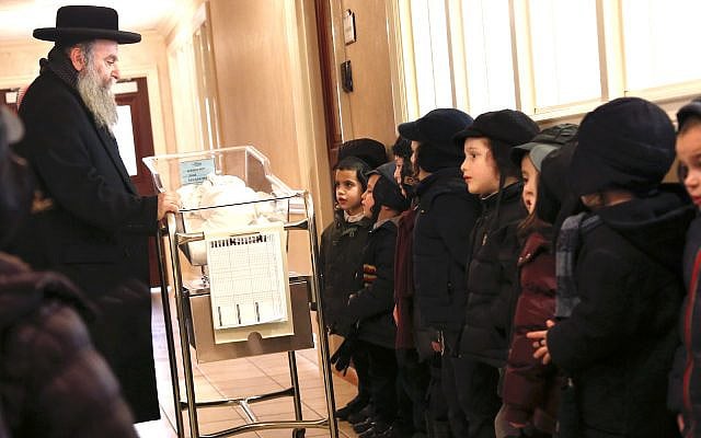 Illustrative: School children pray with a recently born child at Aishes Chayil, a postpartum recovery center, in Kiryas Joel. N.Y. Feb. 16, 2017 (AP Photo/Seth Wenig)