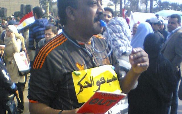 Photo in February 2011 taken by Khalid, in Tahrir Square in Egypt. The individual in the photo is dressed like a referee and has a sign that reads "the people are the referee".